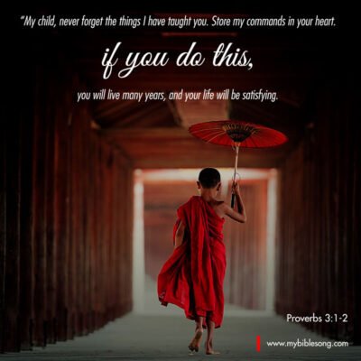 My child, never forget the things I have taught you. Store my commands in your heart. If you do this, you will live many years, and your life will be satisfying. Proverbs 3:1-2 Young Buddhist monk holding a red umbrella walking through a wooden corridor, inspiring faith and spiritual growth. Perfect for faith-based content, prayer, meditation, and religious inspiration.