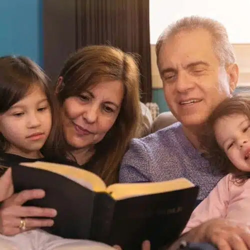 Family reading Bible together at home, emphasizing faith, family bonding, and spiritual growth. Perfect image for Christian family activities and religious devotion.