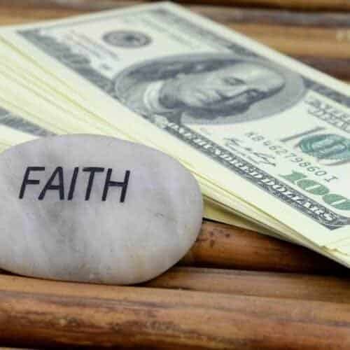 Stepping Through the Finance Sector Managing Your Finances with Guidance from Powerful Scripture My Bible Song 2025 Faith and money concept, stack of hundred-dollar bills next to a pebble engraved with the word "FAITH" on a wooden surface.