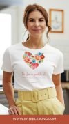 Beautiful woman wearing a white faith-themed t-shirt with floral heart design and biblical verse, promoting Christian music and worship through My Bible Song website.