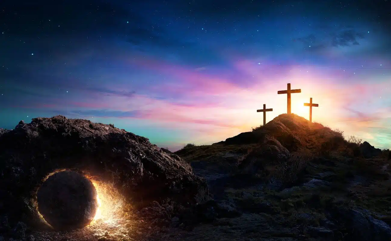 Beautiful scene of three crosses on a hill during sunset with a glowing tomb in the foreground, symbolizing Jesus Christ’s resurrection, faith, and Christian worship.