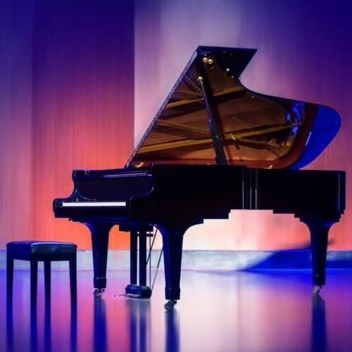 Elegant grand piano on stage with colorful lighting, perfect for worship music, Christian songs, and musical performances. Ideal for church events and spiritual gatherings.