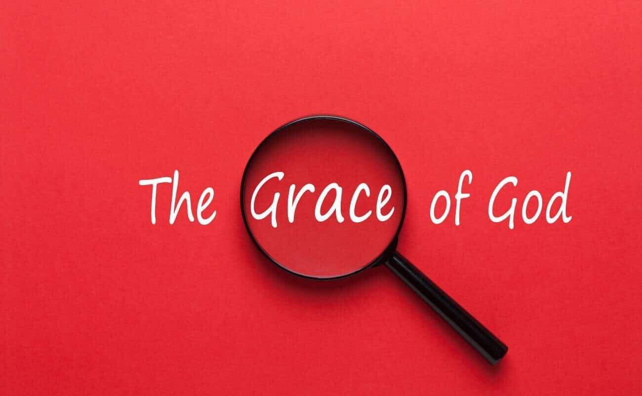 Magnifying glass over the words "The Grace of God" on a red background, emphasizing divine mercy and Christian faith.