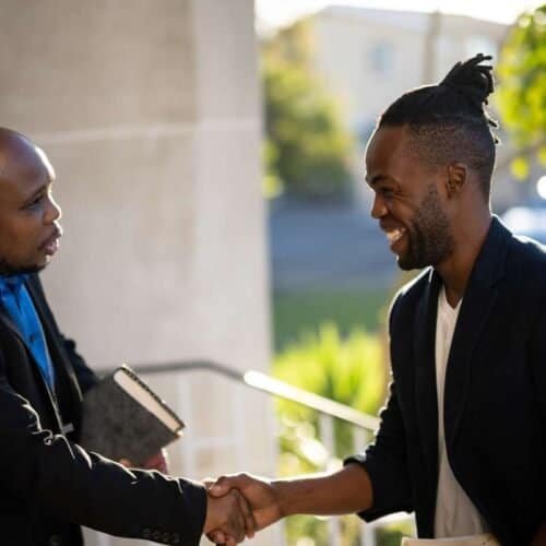 10 Heartfelt Ascension Day Greetings to Inspire Your Celebrations My Bible Song 2025 Friendly handshake between diverse men outside, symbolizing faith, community, and spiritual connection with a focus on Christian values and Bible-based worship.