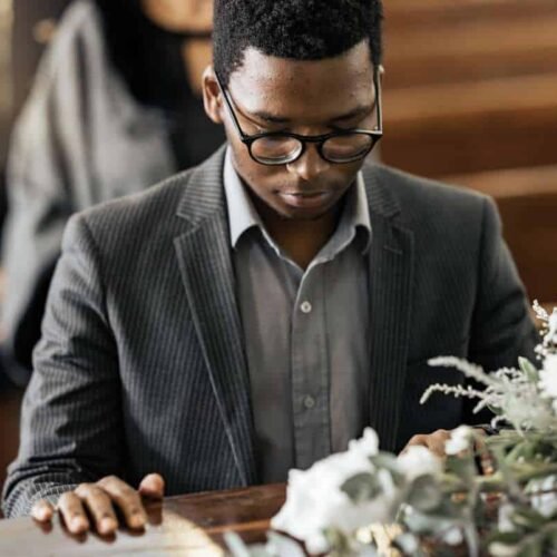 Praying person at church table with flowers, worship, Christian faith, prayer, spirituality, devotion, religious service, Jesus Christ, Bible, worship music, faith-based community, praise, and Christian lifestyle.