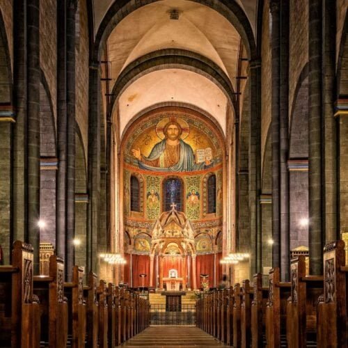 Beautiful interior of a historic church with religious artwork and wooden pews, perfect for worship and spiritual reflection.