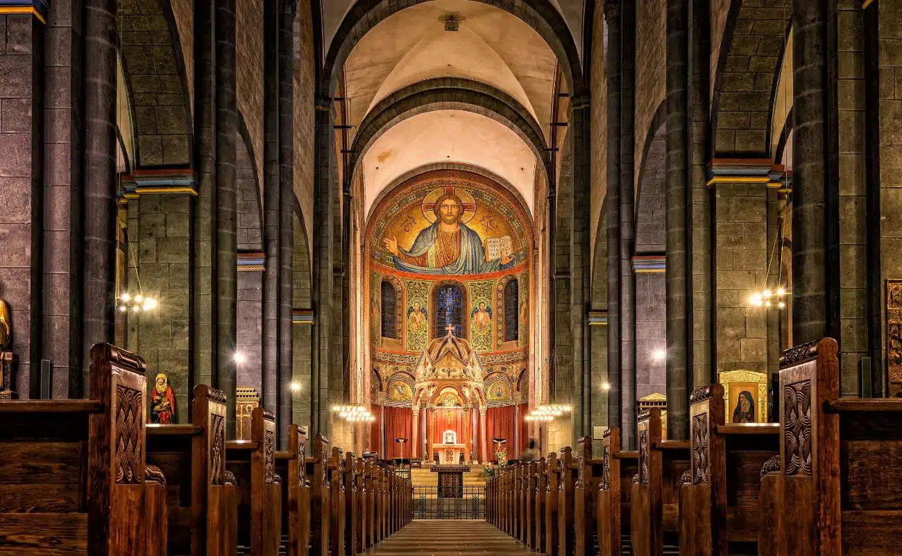 Beautiful interior of a historic church with religious artwork and wooden pews, perfect for worship and spiritual reflection.