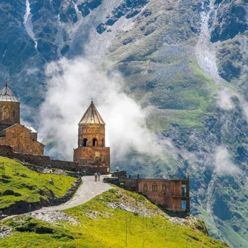 Ancient stone church on a mountain with lush green grass and dramatic clouds, symbolizing faith and spirituality, ideal for Christian worship and biblical song themes.