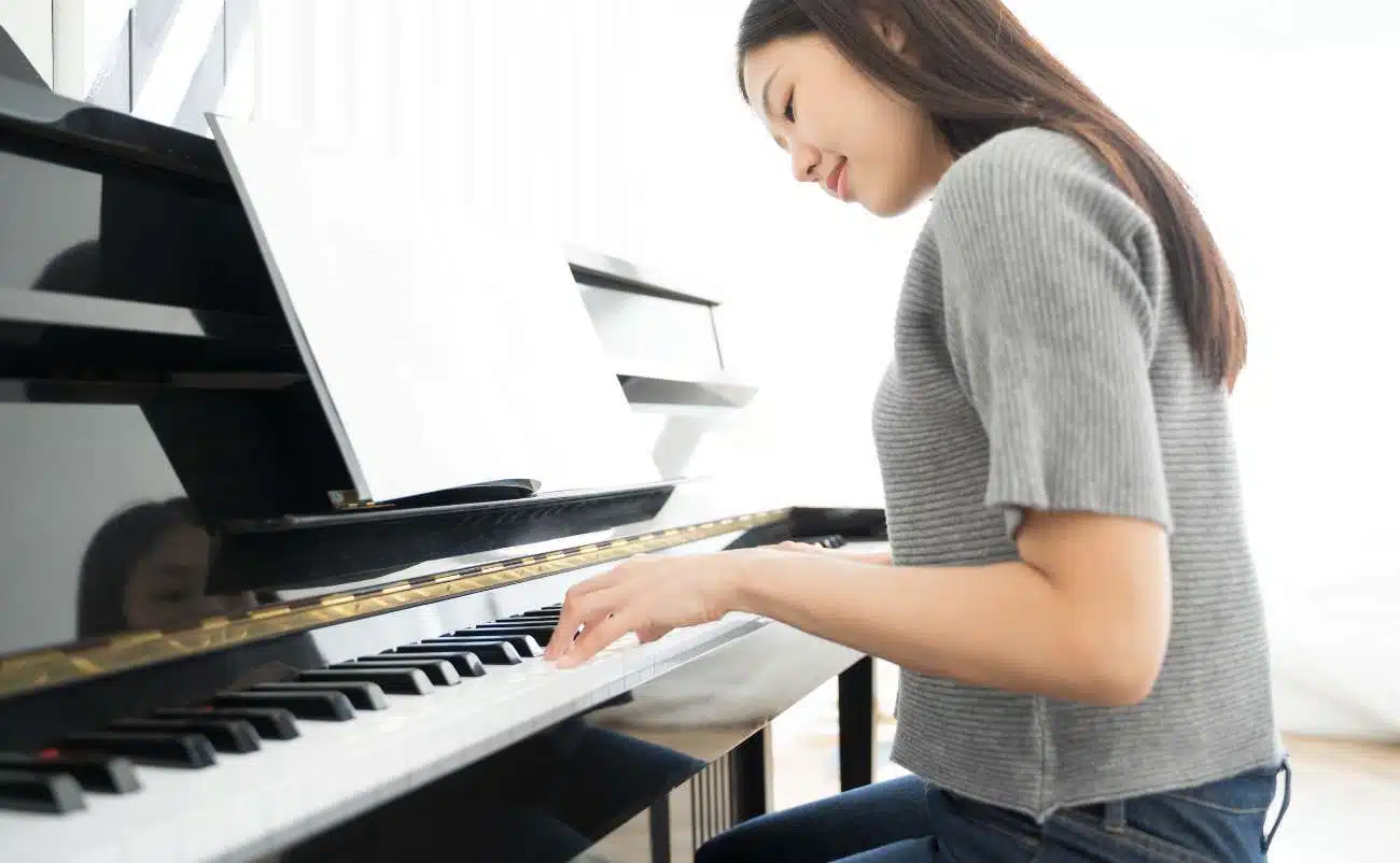 Piano-playing woman singing praise and worship music, joyful Christian worship, young woman with piano, faith-based music, uplifting spiritual song, music for praise and worship, Christian music lover, religious music, worship session, gospel music.