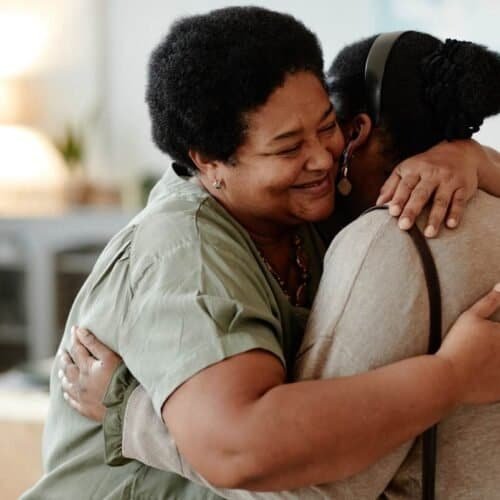 Transform Your Heart: 25 Powerful Bible Verses to Love Your Enemies My Bible Song 2025 Loving embrace between two women, demonstrating warmth, support, and friendship, in a cozy indoor setting. Perfect for promoting themes of faith, community, and emotional connection from My Bible Song.