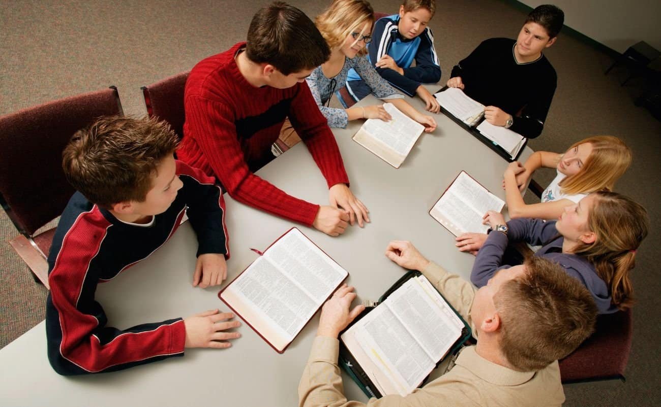 Children and adults studying the Bible together during a church or Sunday school class, promoting faith, religious education, and spiritual growth.