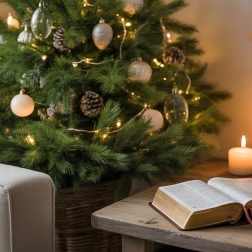 Christmas decorated Christmas tree with ornaments and lights in cozy living room with candles and open Bible, creating a warm and spiritual holiday atmosphere.