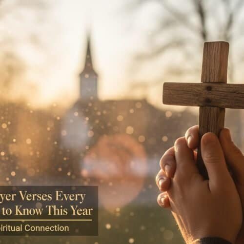 Hand holding small wooden cross in front of church window at sunset.