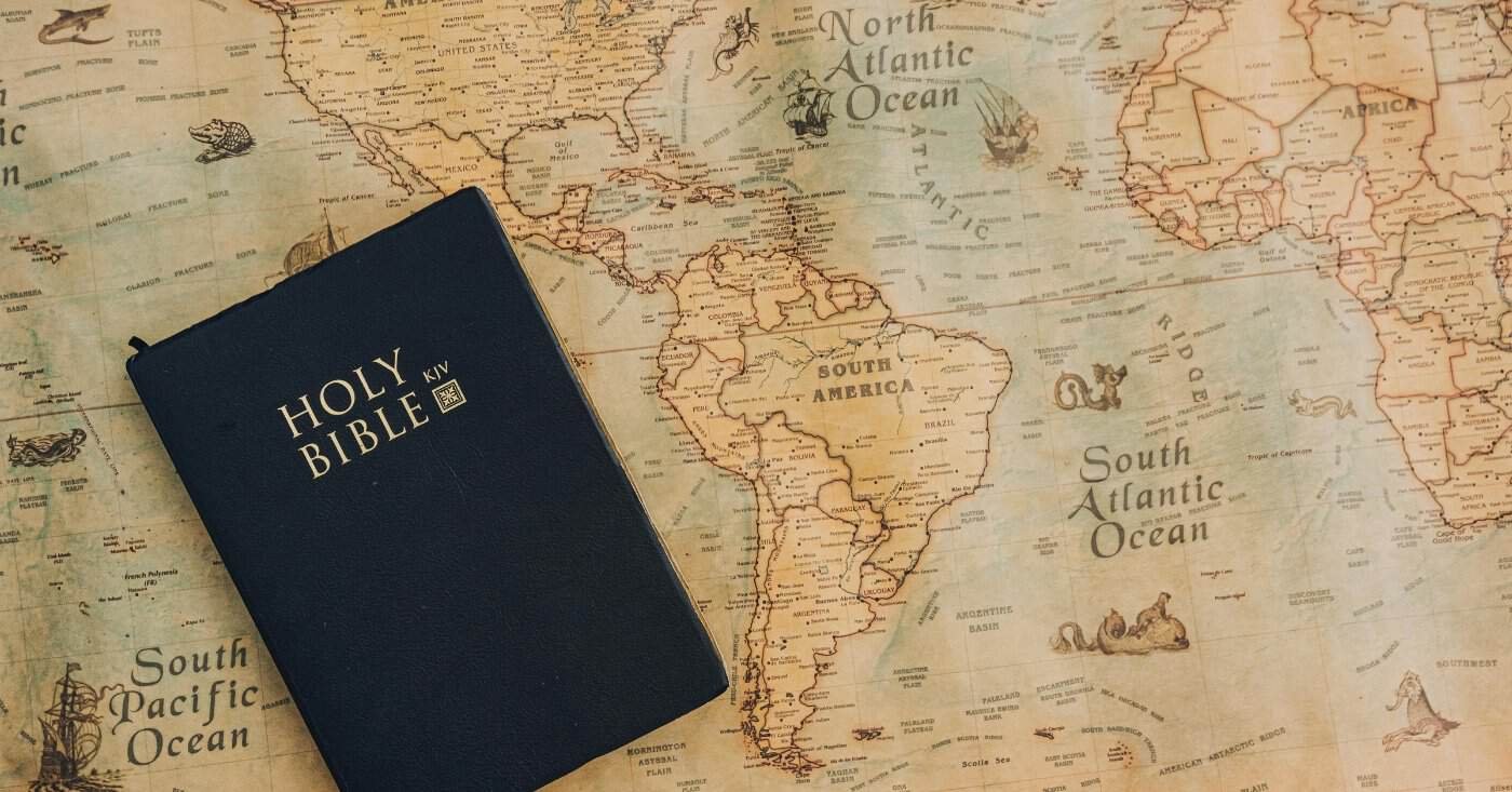 A Holy Bible resting on a vintage world map, symbolizing faith and global outreach, perfect for Christian worship, Bible study, and religious inspiration.